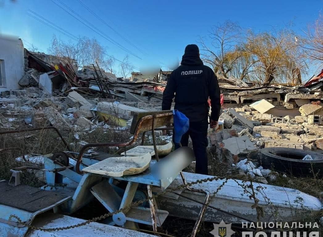 поліцейський на фоні руйнувань внаслідок російської атаки