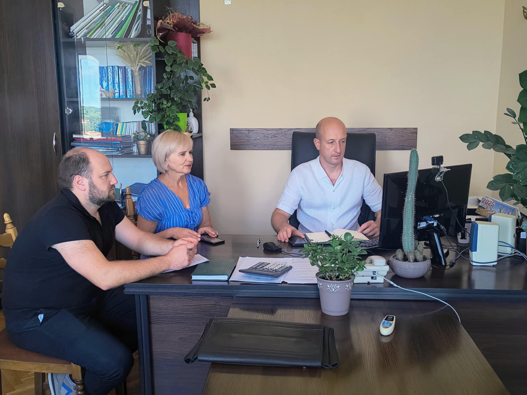 Директор та фахівці Департаменту в кабінеті за робочим столом перед ними монітор комп'ютера