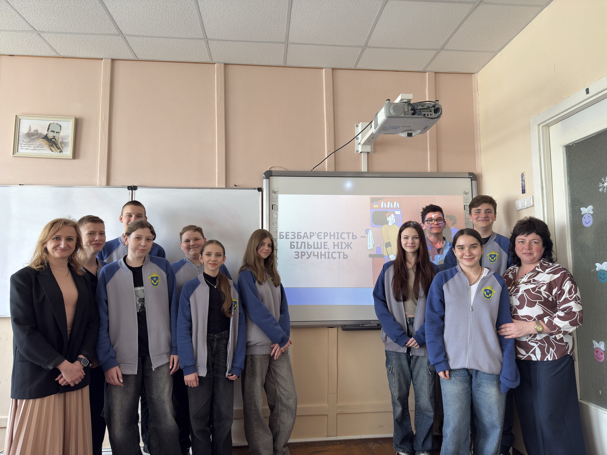 Люди стоять біля екрану проектора "Безбар'єрність більше, ніж зручність" Люди стоять біля екрану проектора "Безбар'єрність більше, ніж зручність"