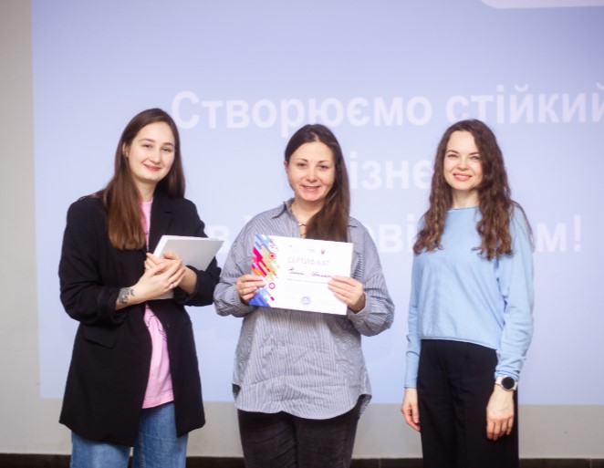 Група усміхнених учасниць навчання, які тримають в руках сертифікати про успішне завершення курсу.