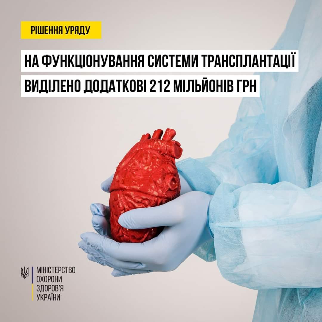 Людина в синьому костюмі тримає серце.