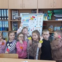 Діти фотографуються разом в навчальному приміщенні. У всіх на зап'ястях видно паперові браслети