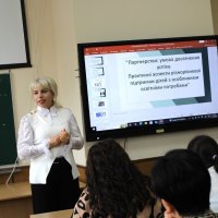 Фахівець представляє матеріал аудиторії. позаду спікера видно презентацію