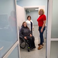 Жінки оглядають приміщення. Одна з учасниць у кріслі колісному