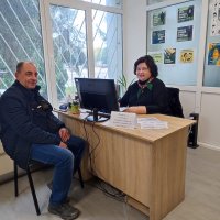 Люди сидять за робочим столом. Ознайомлюються з інформаційними матеріалами