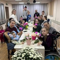 Майстер-клас або спільна творча робота: діти та дорослі сидять за столом, на якому розміщені горщики з квітами