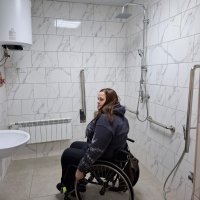 Дівчина на кріслі колісному оглядає вбиральню