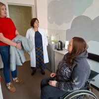 Жінки у кабінеті щось обговорюють. Одна з учасниць розмови у кріслі колісному