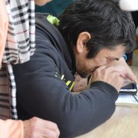 Чоловік сидить за столом і читає за допомогою пристрою для читання