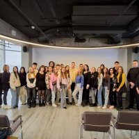 Фото з заходів. Група людей фотографується у приміщенні