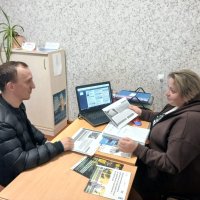 Люди сидять за робочим столом. Ознайомлюються з інформаційними матеріалами